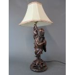 An early 20th century Chinese carved wooden figure of a Lohan mounted as a table lamp, overall H.