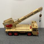 A large wooden vintage toy crane with a copy railway clock hanging on the hook, L. 75cm.