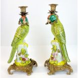 A pair of Continental ormolu mounted porcelain parrot candlesticks, H. 26cm.