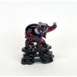 An interesting Oriental faux amber elephant and stand, H. 9cm.