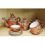 A small Japanese four setting porcelain tea set decorated with dragons.