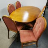 An extending G Plan style teak dining table with cross banded edging and a set of six dining chairs,