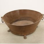 A large two handled iron ice bucket/planter, W. 76cm.