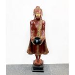 A Thai painted carved wooden figure of a Buddhist monk, H. 100cm.