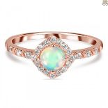 A rose gold on 925 silver ring set with a cabochon cut opal and white stones.