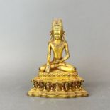 A Tibetan gilt bronze and jewelled figure of a seated Buddha, H. 23cm.