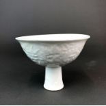 A fine Chinese blanc de chine relief decorated stem cup, Dia. 15cm. H. 11cm.