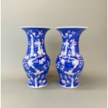 A pair of Chinese porcelain 'prunus' pattern vases with blue and red underglaze decoration, H.