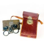 A pair of leather cased folding opera glasses together with a leather case Kodak camera.