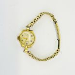 A 9ct gold lady's wristwatch on a gold plated strap.