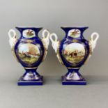 A pair of Continental porcelain two handled vases decorated with hunting scenes, H. 29cm.