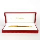A boxed Cartier gold plated ball point pen.