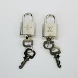 Two Louis Vuitton luggage locks.