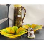 A large French pottery cider jug with two leaf plates and a small porcelaion figural box.