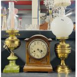 Two brass oil lamps, tallest 57cm, together with an oak mantle clock.