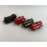 A Hornby 0 gauge wind-up type 40 82011 locomotive together with three tank wagons.