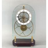 A contemporary glass skeleton clock mounted on a wooden base. H. 36cm.