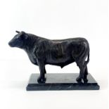 A bronze figure of a bull on a black marble base, H. 17 cm.