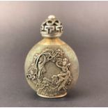A Chinese white metal snuff bottle with relief decoration and four character mark to base, H. 8.