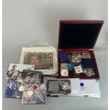 A quantity of commemorative coins and stamps.