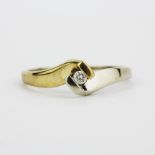 A 9ct yellow and white gold diamond set solitaire ring, (Q).
