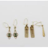 Two pairs of yellow metal drop earrings, one pair set with emeralds, together with a single yellow