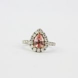 A platinum and 18ct rose gold ring set with a pear cut padparadscha sapphire surrounded by small