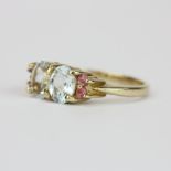 A hallmarked 9ct yellow gold ring set with oval cut aquamarine and pink topaz, (N.5).