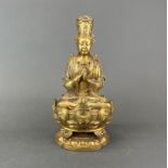 A jewelled Tibetan gilt bronze figure of a seated Deity, H. 27cm.