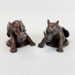 A pair of unusual bronzed metal desk weights of a rhino and a elephant emerging from drain covers,