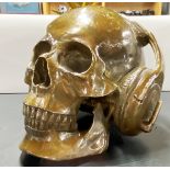A unusual bronze figure of a skull wearing headphones, H. 16cm. W. 20cm.