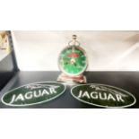 Two cast iron Jaguar signs and a battery operated clock, sign W. 26cm.