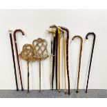 A collection of walking sticks, umbrellas and carpet beaters.