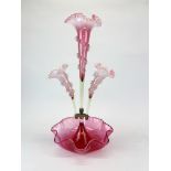 A 19th century cranberry glass epergne with cranberry and vaseline glass flutes, H. 51cm.