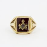 A gent's 10ct yellow gold and ruby Masonic ring, some minor chips to stone, (V.5).