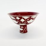 A Chinese Sang de boeuf glazed and white highlighted porcelain stem cup, Dia. 17.5cm. H. 11cm.