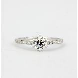 An 18ct white gold (stamped 750) solitaire ring set with a brilliant cut diamond and diamond set