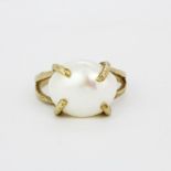 A hallmarked 9ct yellow gold ring set with a large freshwater pearl, pearl L. 1.5cm, (O.5).