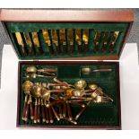 A boxed wood and bronze cutlery set.