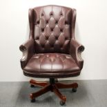 A faux leather adjustable button backed desk chair on wheels, H. 100cm.