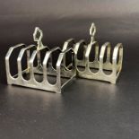 A pair of hallmarked silver toast racks, L. 7.5cm. H. 7.5cm.