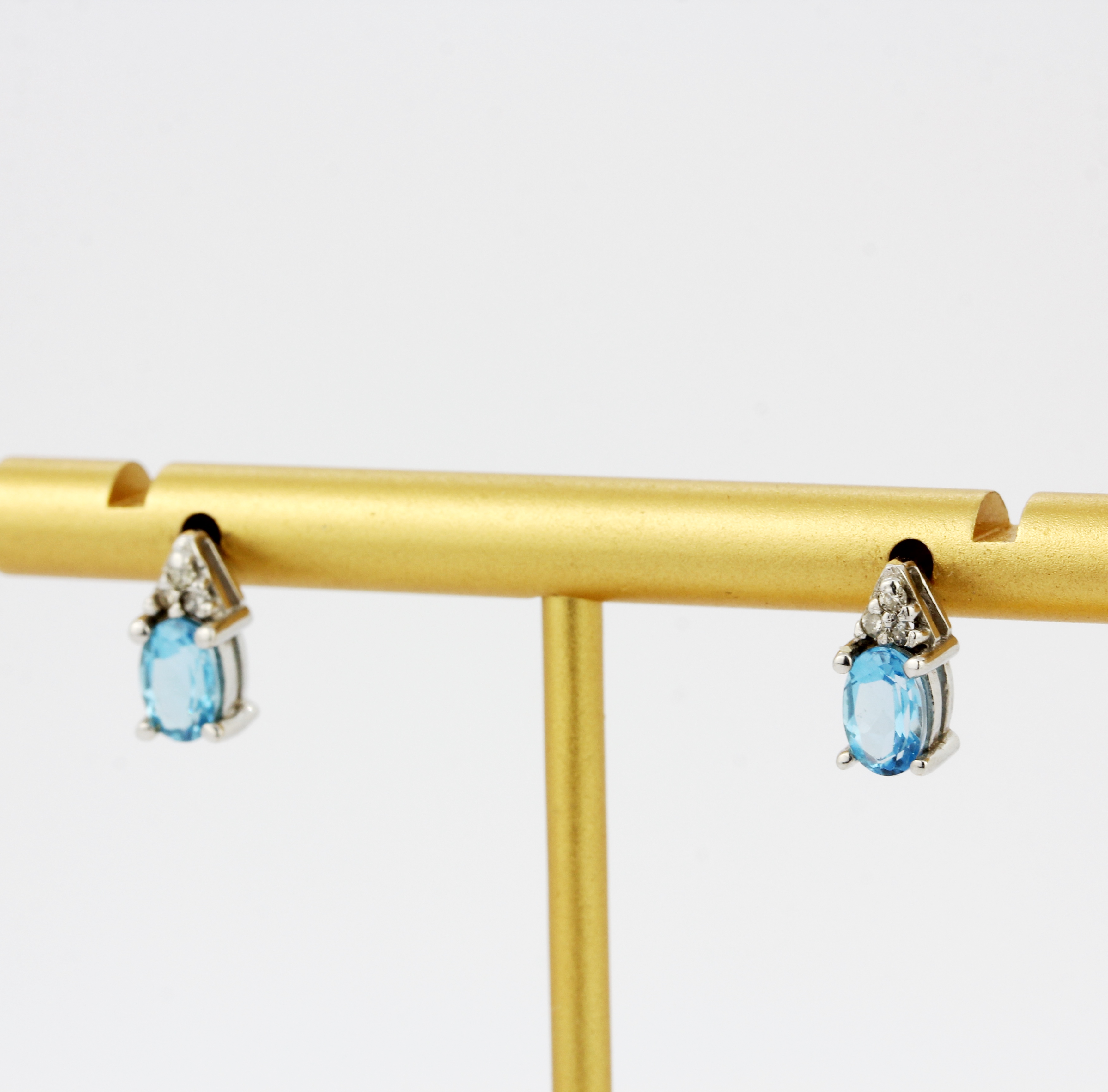 A pair of 9ct white gold stud earrings set with oval cut blue topaz and diamonds, L. 1cm. - Image 2 of 3