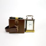 A miniature Matthew Norman brass carriage clock with original carrying case and key, H. 7.5cm.