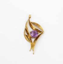 A hallmarked 9ct yellow gold pendant set with a large round cut amethyst, L. 6cm.
