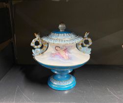 A continental porcelain cherub urn, H. 14cm, W. 23cm.