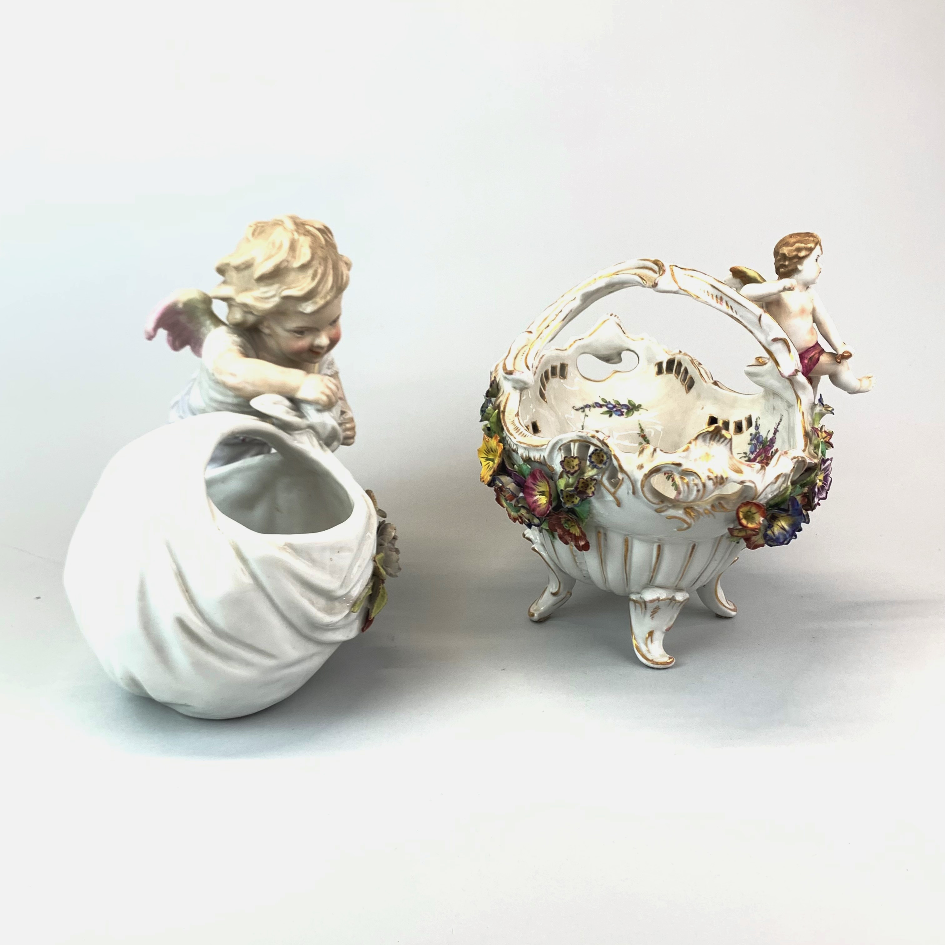 A 19th century German porcelain figure of a cherub with a basket, H. 21cm. together with a further - Image 2 of 3