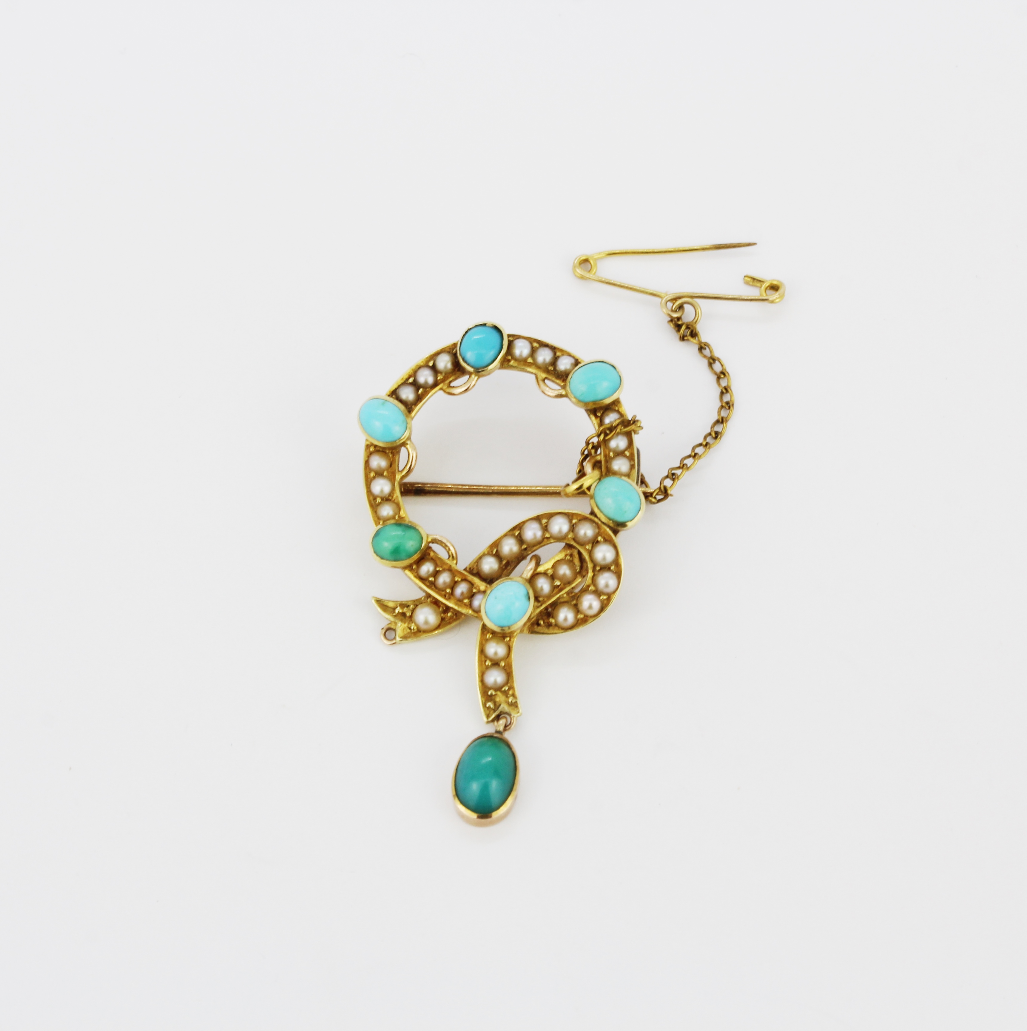 A yellow metal (tested high carat gold) brooch set with turquoise and seed pearls, L. 4.5cm.