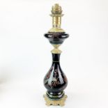 A large 19th century black glass and brass oil lamp converted for electricity, H. 62cm.