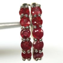 A pair of 925 silver earrings set with round cut rubies, L. 1.6cm.