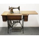 An oak and cast iron Singer treadle sewing machine, 90 x 77 x 45cm.